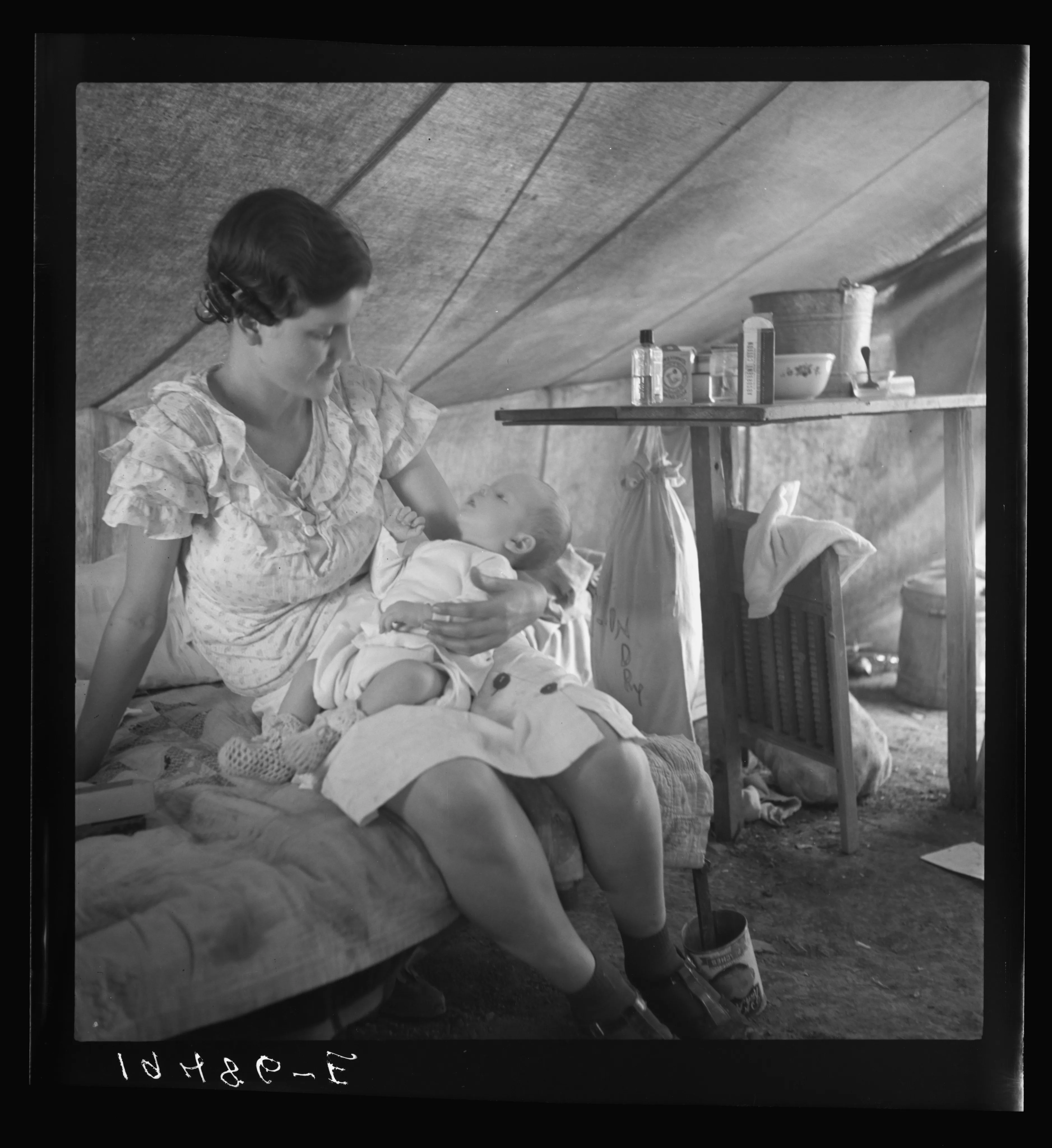 A young mother holding an infant in an intimate caregiving scene.