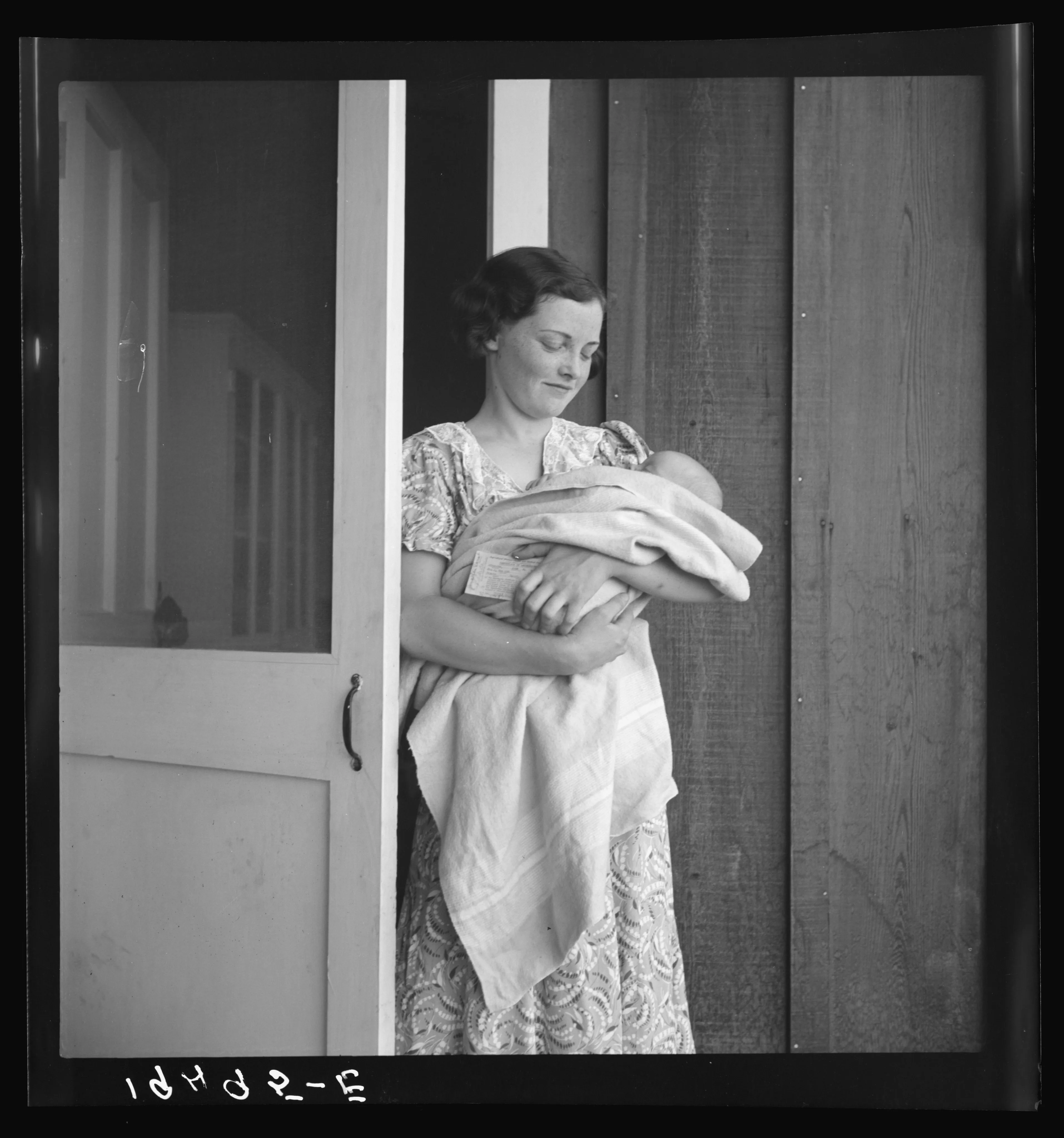 A mother and infant in a camp setting, described by the collection in connection with seeking medical assistance.